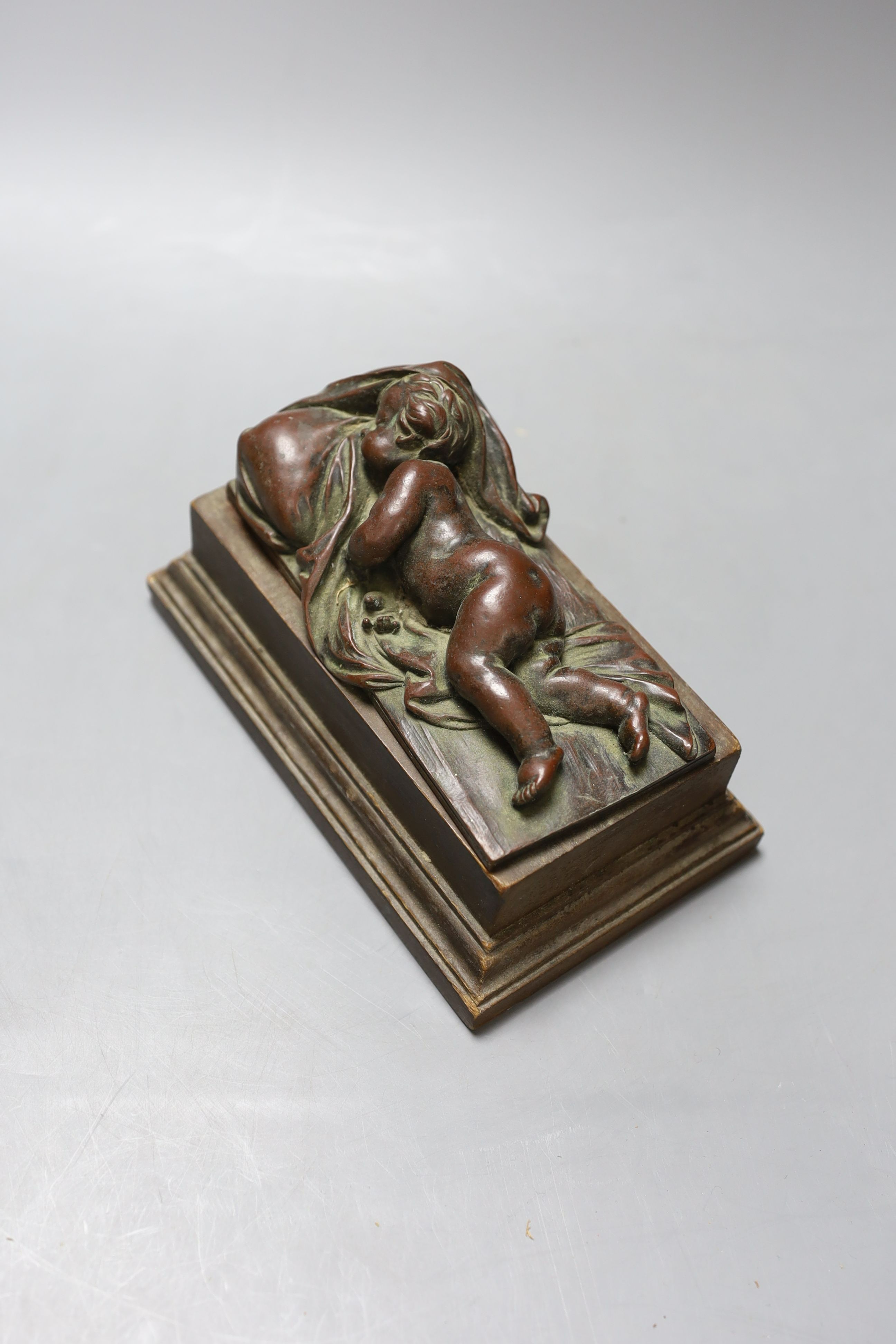 An electrotype figure of a recumbent putti on wooden base
